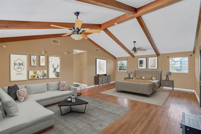 bedroom featuring light hardwood / wood-style floors, multiple windows, vaulted ceiling with beams, and ceiling fan