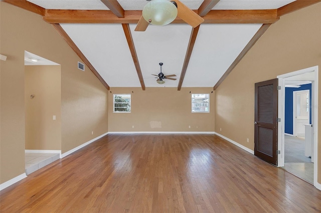 unfurnished living room featuring beam ceiling, hardwood / wood-style flooring, and ceiling fan