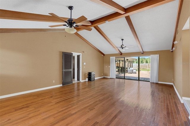 unfurnished living room featuring ceiling fan, hardwood / wood-style flooring, a textured ceiling, and vaulted ceiling with beams