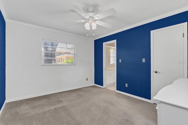 spare room with crown molding, light carpet, and ceiling fan