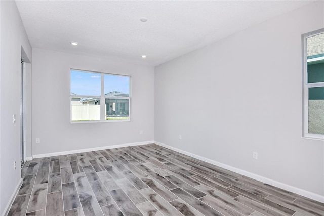 spare room featuring a textured ceiling and hardwood / wood-style floors