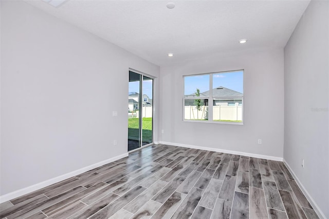 unfurnished room with a textured ceiling and light hardwood / wood-style floors