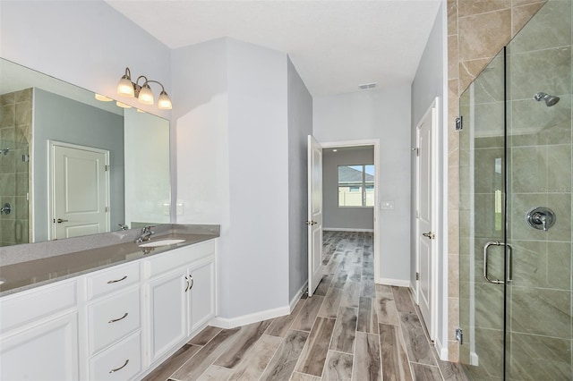 bathroom featuring vanity, a shower with door, and hardwood / wood-style floors