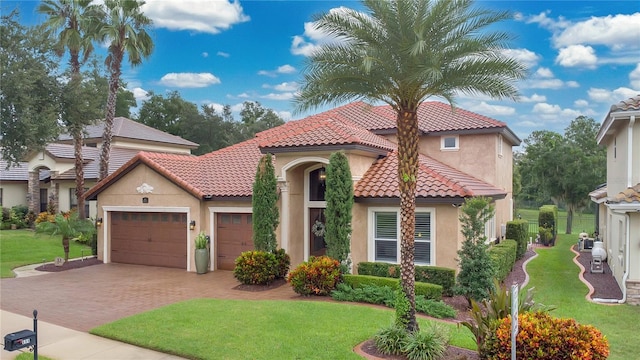 mediterranean / spanish home with a garage and a front yard