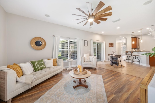 living room with ceiling fan and dark wood-type flooring