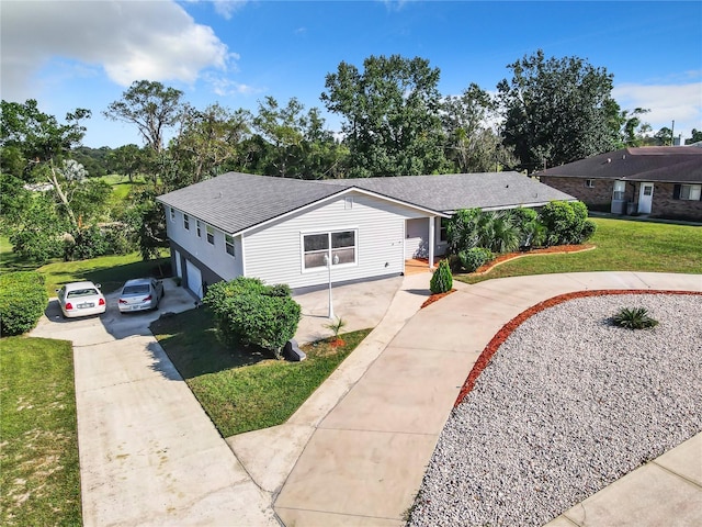 2281 E Union Cir, Deltona, FL 32725 - view of front of home with driveway, an attached garage, a shingled roof, and a front lawn