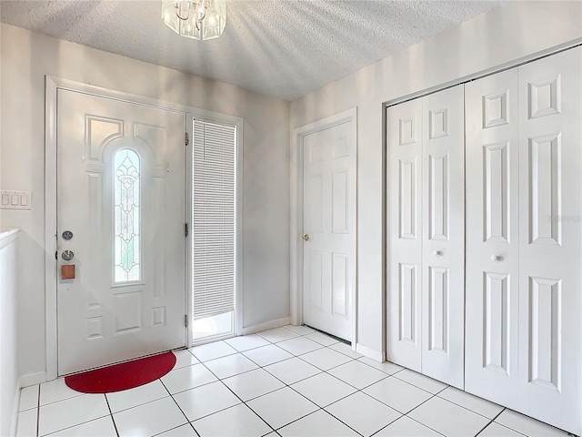 2281 E Union Cir, Deltona, FL 32725 - entryway featuring a textured ceiling, light tile patterned floors, and baseboards