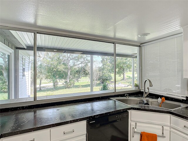 2281 E Union Cir, Deltona, FL 32725 - kitchen featuring white cabinetry, dark stone counters, black dishwasher, and a sink