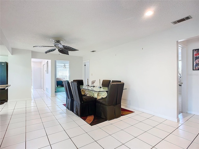 tiled dining room with ceiling fan and a textured ceiling