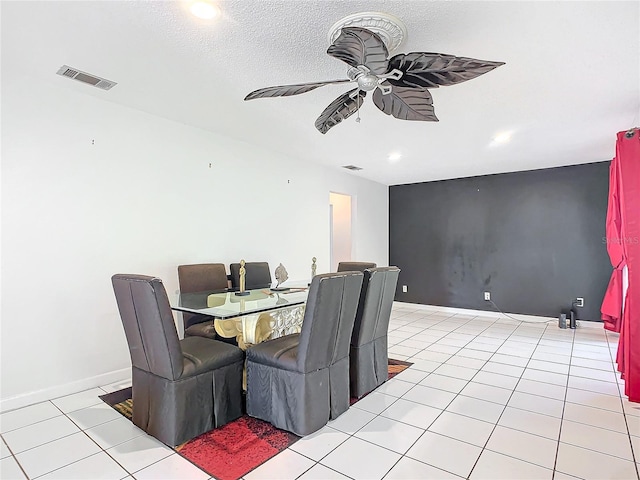 tiled dining room with a textured ceiling and ceiling fan