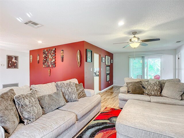 2281 E Union Cir, Deltona, FL 32725 - living room featuring a textured ceiling, visible vents, a ceiling fan, and light wood-type flooring