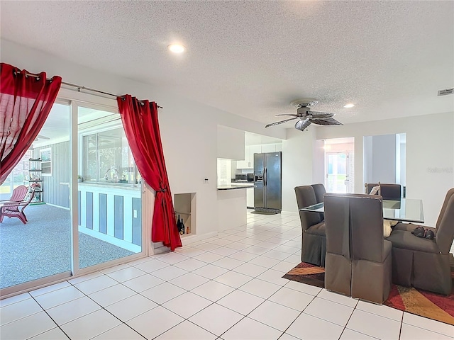 tiled dining area featuring a textured ceiling and ceiling fan