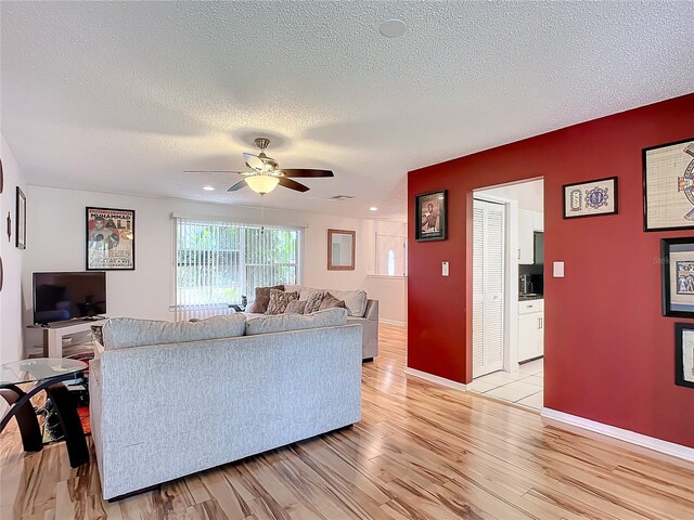2281 E Union Cir, Deltona, FL 32725 - living room featuring baseboards, ceiling fan, a textured ceiling, and light wood finished floors