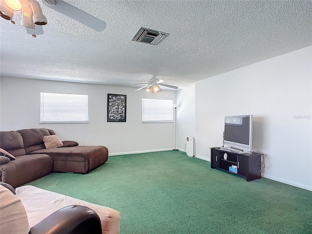 carpeted living room featuring ceiling fan, a healthy amount of sunlight, and a textured ceiling