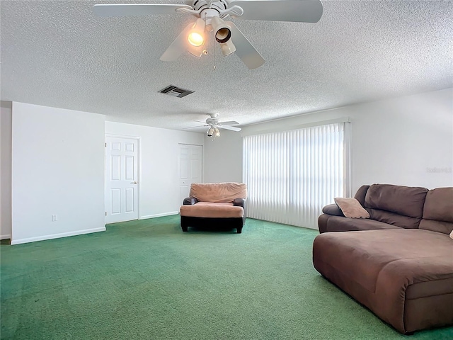 carpeted living room featuring ceiling fan and a textured ceiling