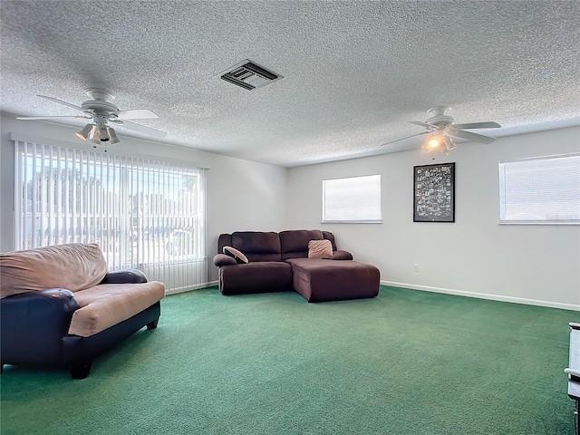 carpeted living room featuring a textured ceiling and ceiling fan