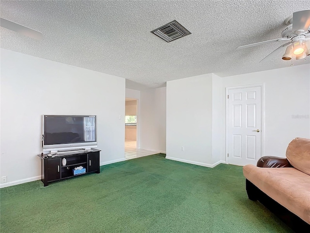 living area featuring a textured ceiling, carpet, and ceiling fan