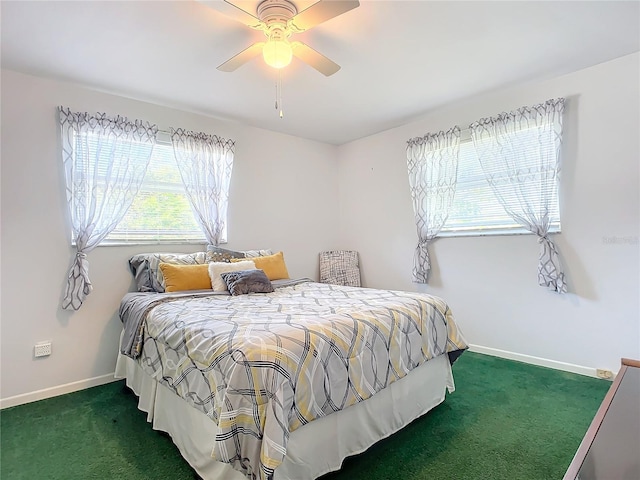 bedroom featuring dark colored carpet, multiple windows, and ceiling fan