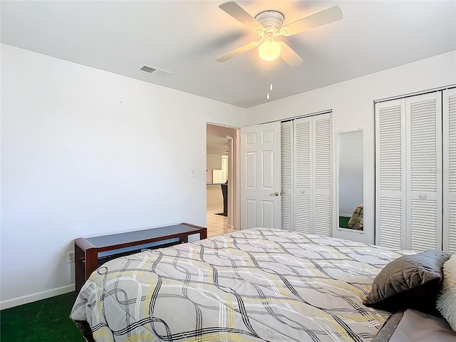 bedroom with ceiling fan, multiple closets, and carpet floors