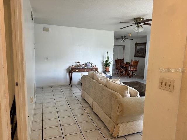 living room featuring light tile patterned flooring and ceiling fan