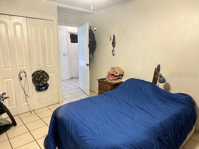 bedroom with a closet and light tile patterned floors