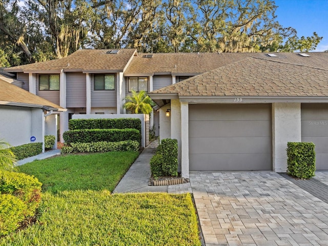 view of front of property with a garage and a front lawn