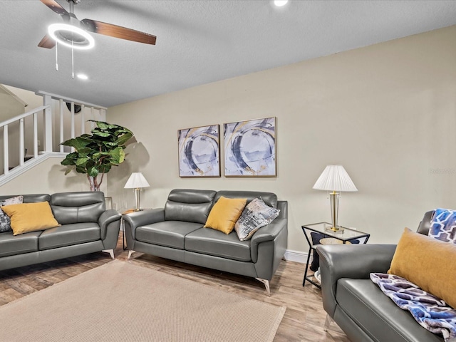 living room featuring hardwood / wood-style floors, a textured ceiling, and ceiling fan