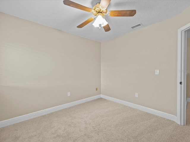 carpeted spare room featuring ceiling fan and a textured ceiling