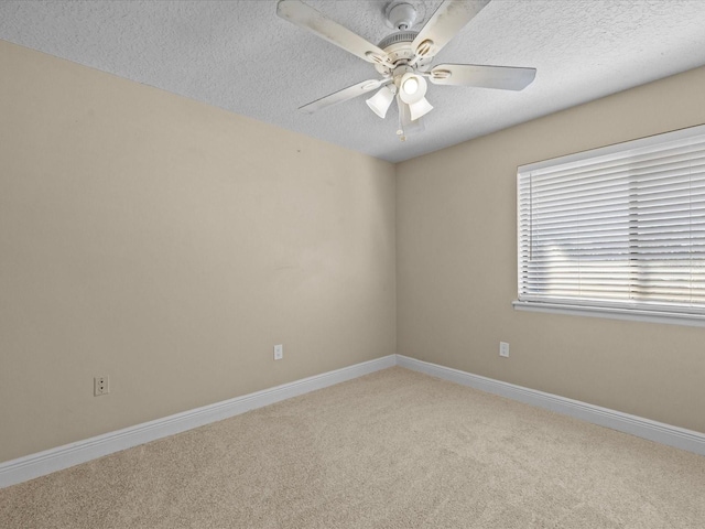 empty room featuring light carpet, ceiling fan, and a textured ceiling