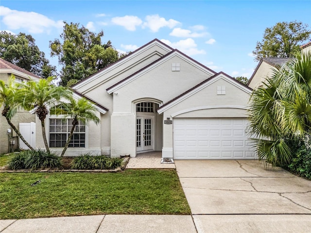 view of front facade with a garage, a front yard, and french doors