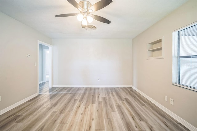 unfurnished room with light wood-type flooring, ceiling fan, and built in features