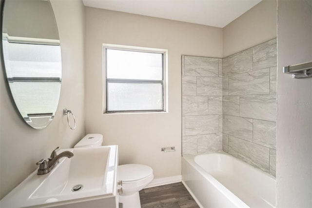 full bathroom with wood-type flooring, vanity, tiled shower / bath, and toilet