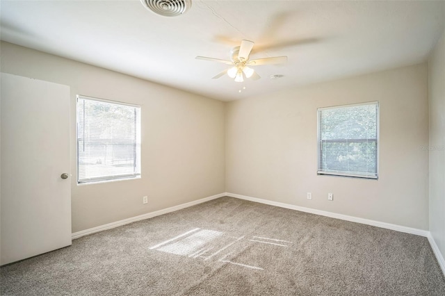 empty room featuring carpet floors, a healthy amount of sunlight, and ceiling fan