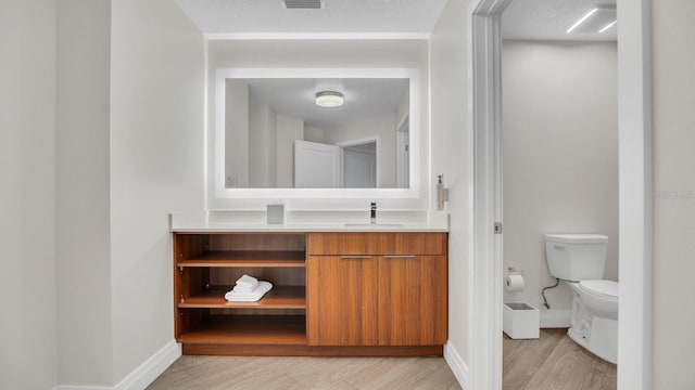 bathroom featuring hardwood / wood-style floors, vanity, and toilet