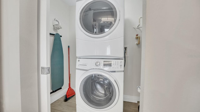 laundry area with light wood-type flooring and stacked washer and dryer