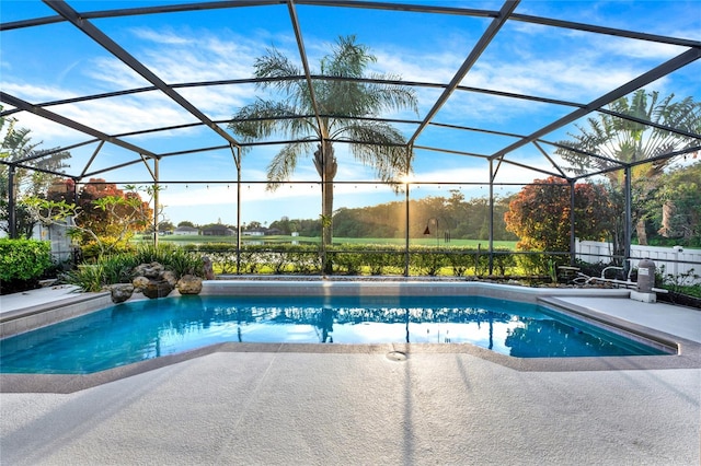 view of pool with glass enclosure and a patio