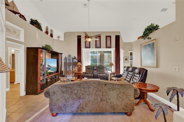 tiled living room with ceiling fan and high vaulted ceiling