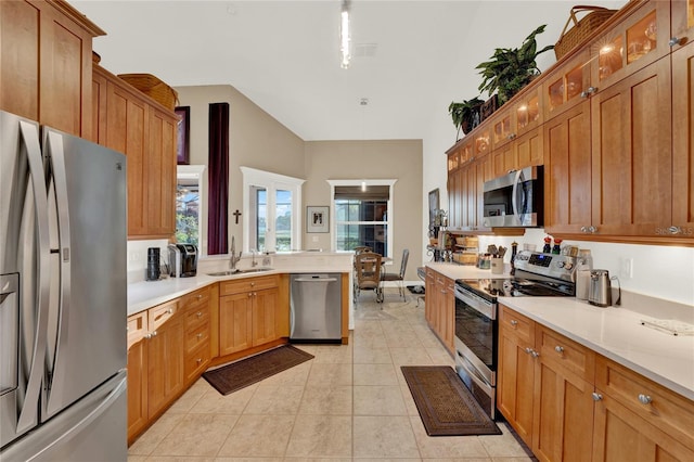 kitchen featuring lofted ceiling, sink, light tile patterned floors, and stainless steel appliances