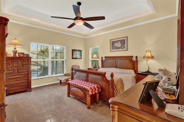 carpeted bedroom with a raised ceiling, ceiling fan, and ornamental molding