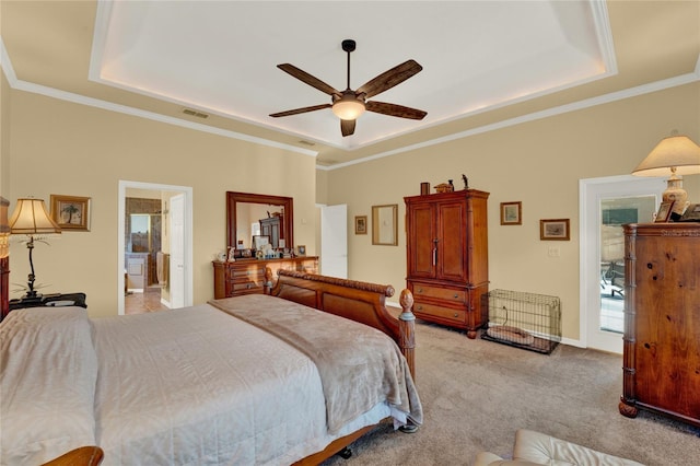 bedroom featuring light carpet, a raised ceiling, ceiling fan, crown molding, and connected bathroom