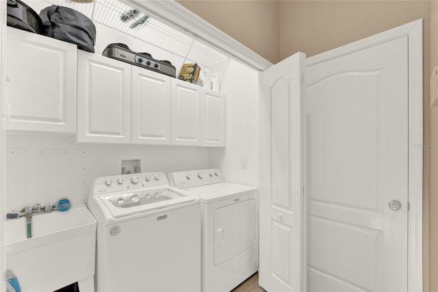 washroom featuring cabinets, washing machine and dryer, and sink