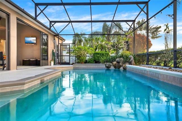 view of pool with a patio area and a lanai