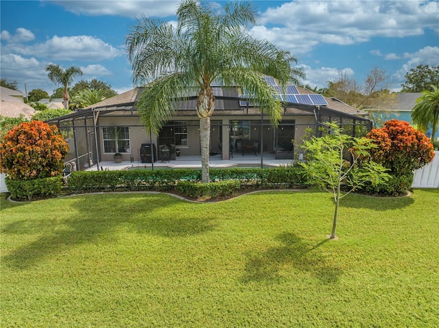 back of property with a lawn, glass enclosure, and a patio