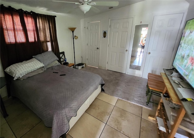 tiled bedroom featuring ceiling fan