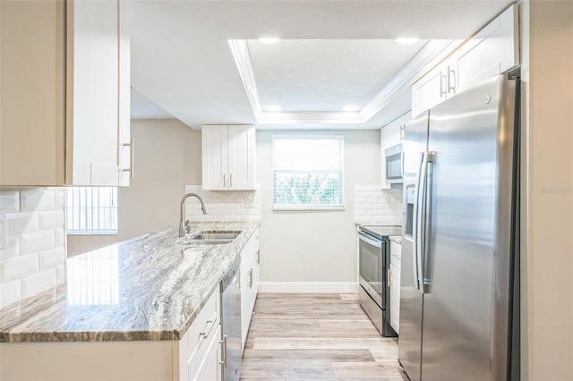 kitchen featuring light stone countertops, white cabinets, decorative backsplash, and appliances with stainless steel finishes