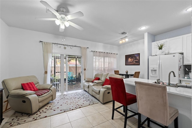 tiled living room featuring ceiling fan and sink