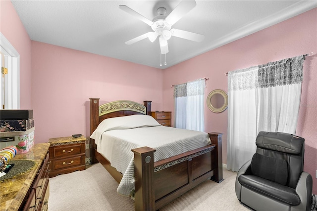 bedroom with ceiling fan and light carpet