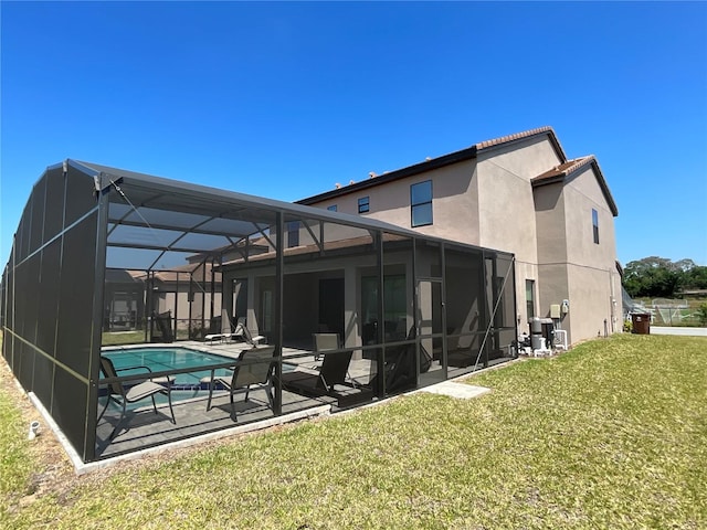 rear view of property with a patio, a yard, and a lanai