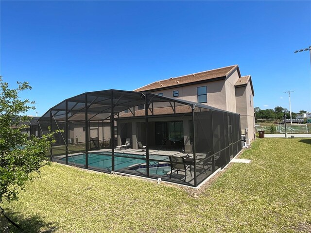 226 Macaulays Cv, Haines City, FL 33844 - back of house featuring a pool with connected hot tub, a patio, a lawn, stucco siding, and a lanai
