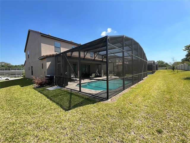 view of swimming pool featuring glass enclosure, a yard, and a patio area